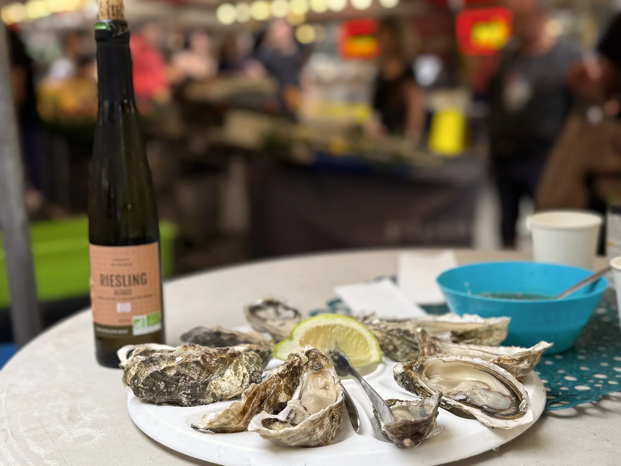 Oysters and a glass of riesling on a market table