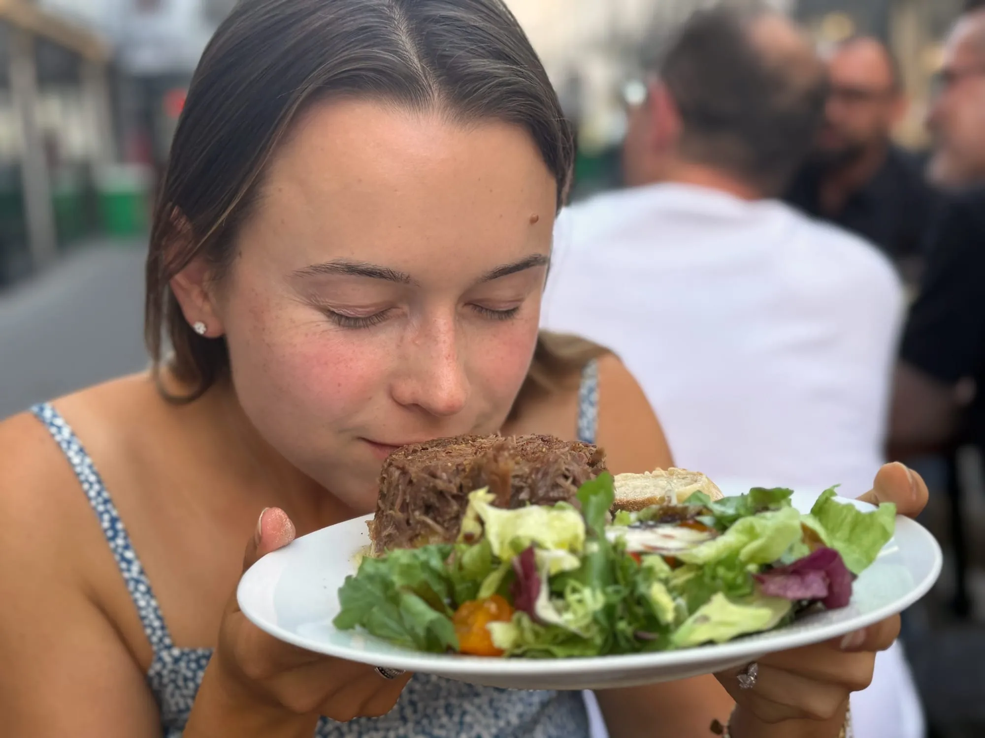 Guest leaning in to smell a hot parmentier dish at a bistro table