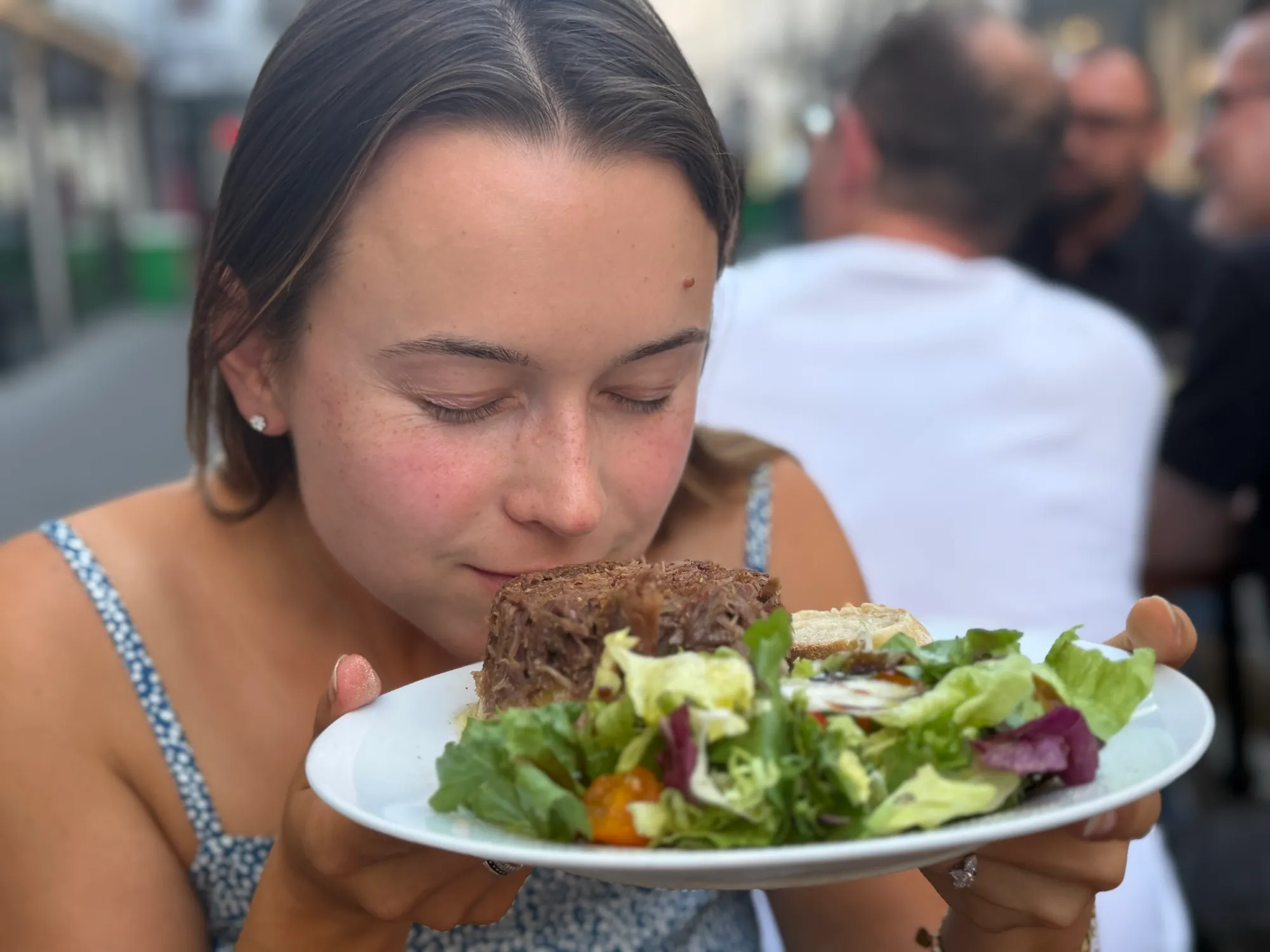 Guest leaning in to smell a hot parmentier dish at a bistro table