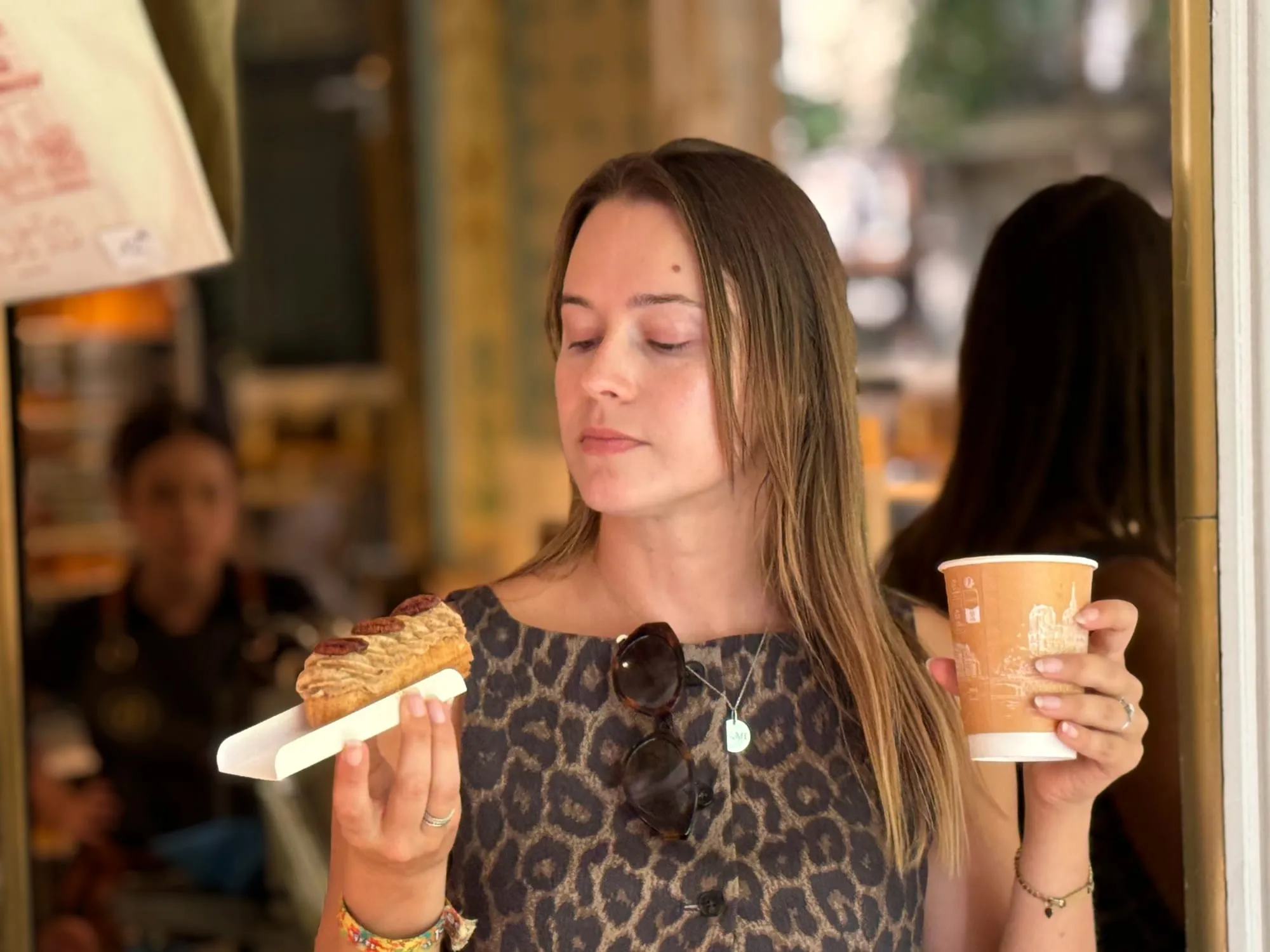 Guest tasting a pastry with coffee at a small table