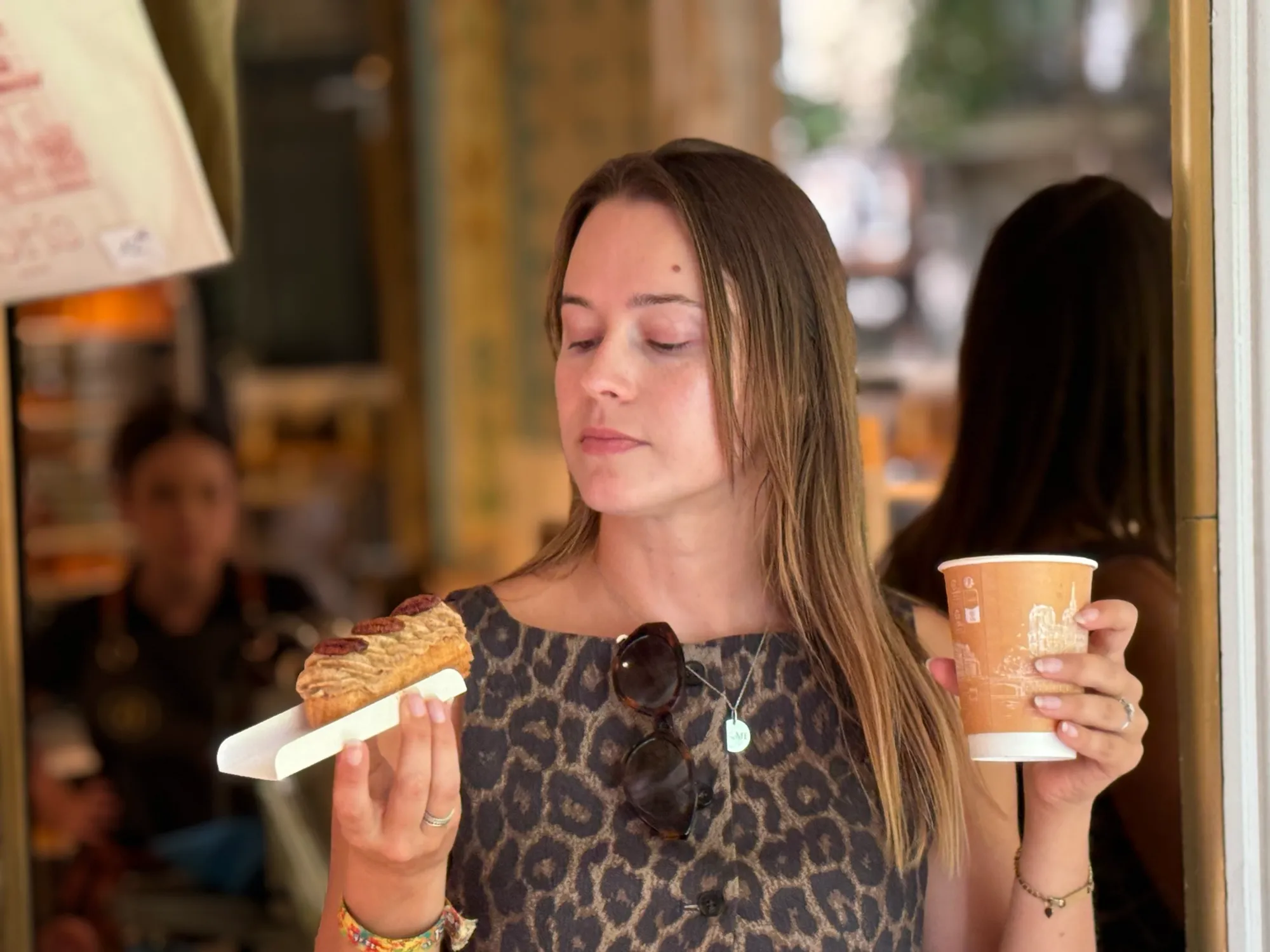 Guest tasting a pastry with coffee at a small table